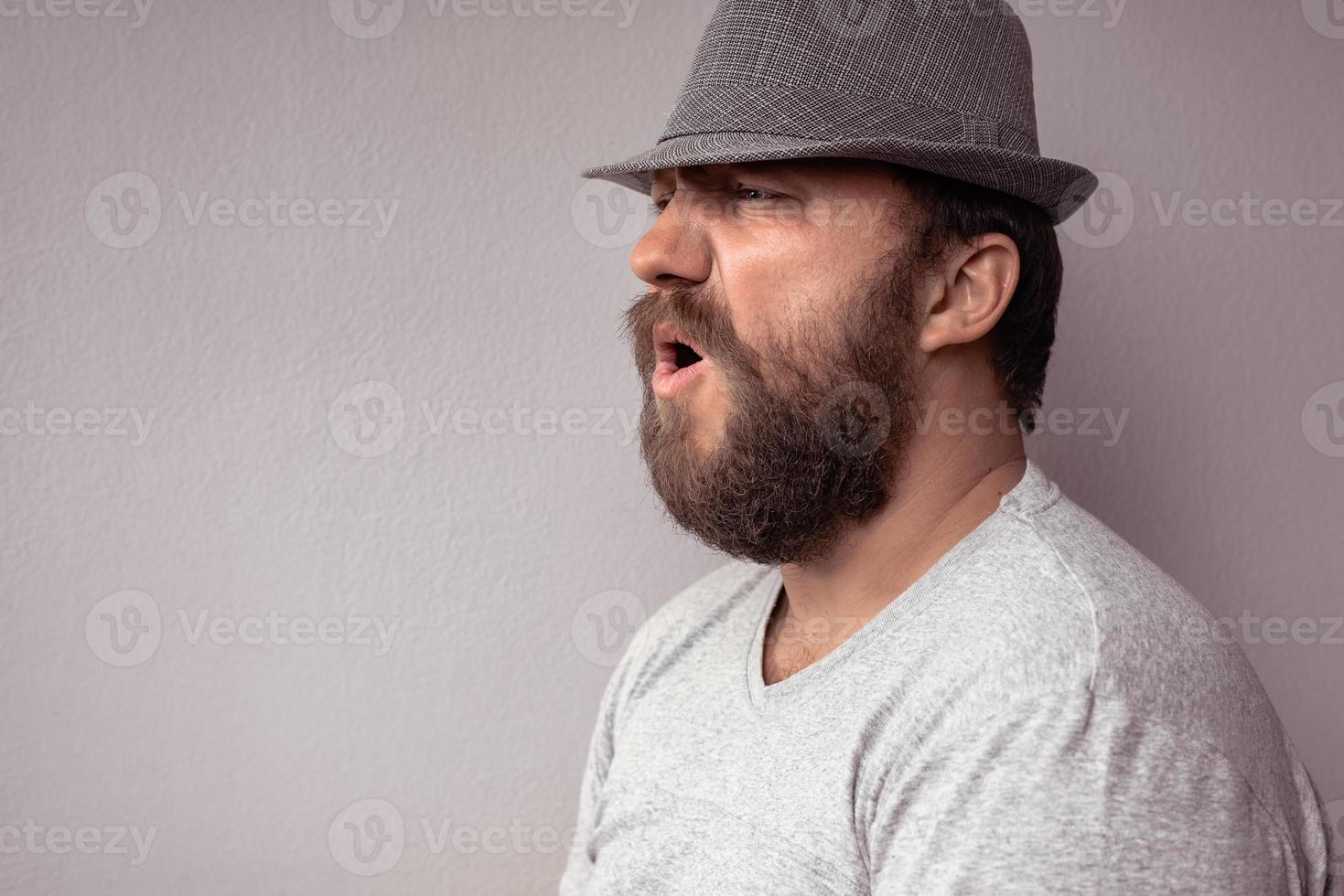 Side portrait of a bearded man shouting photo