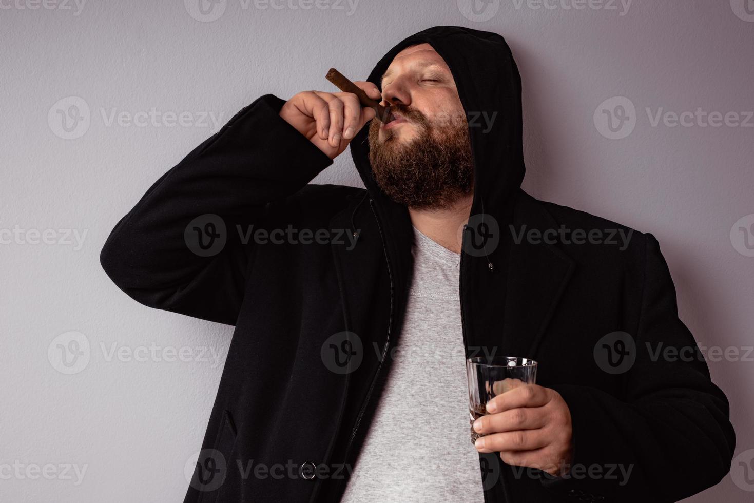 Handsome elegant bearded man wearing black coat with hood photo