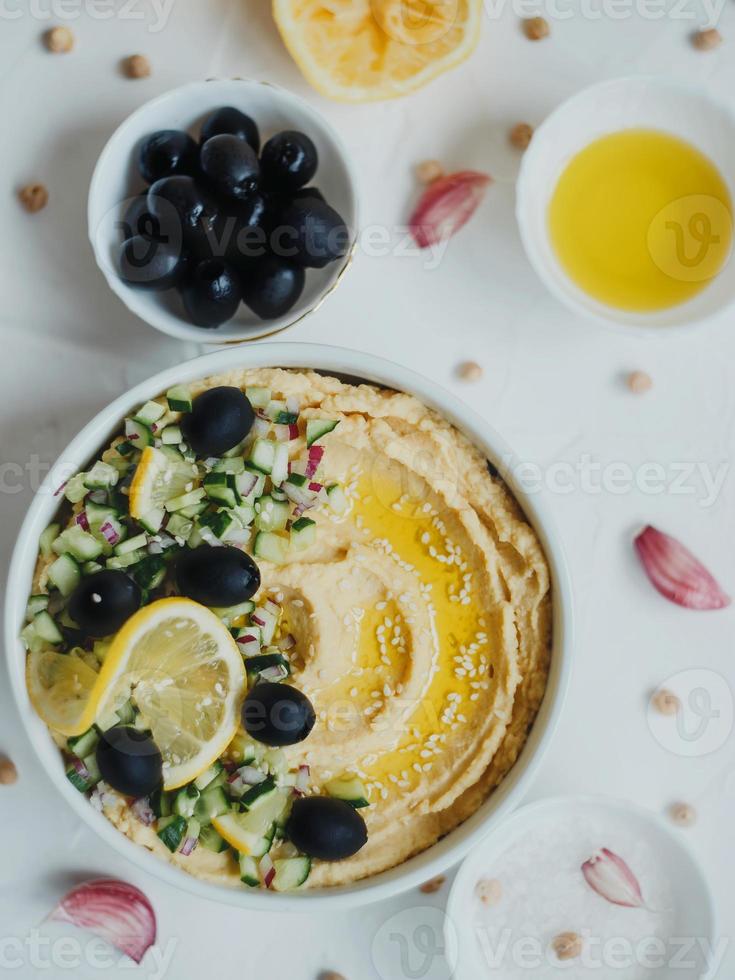 hummus de garbanzos, con aceite de oliva, aceitunas, limón, ajo, ajonjolí, cebolla y pepino. foto