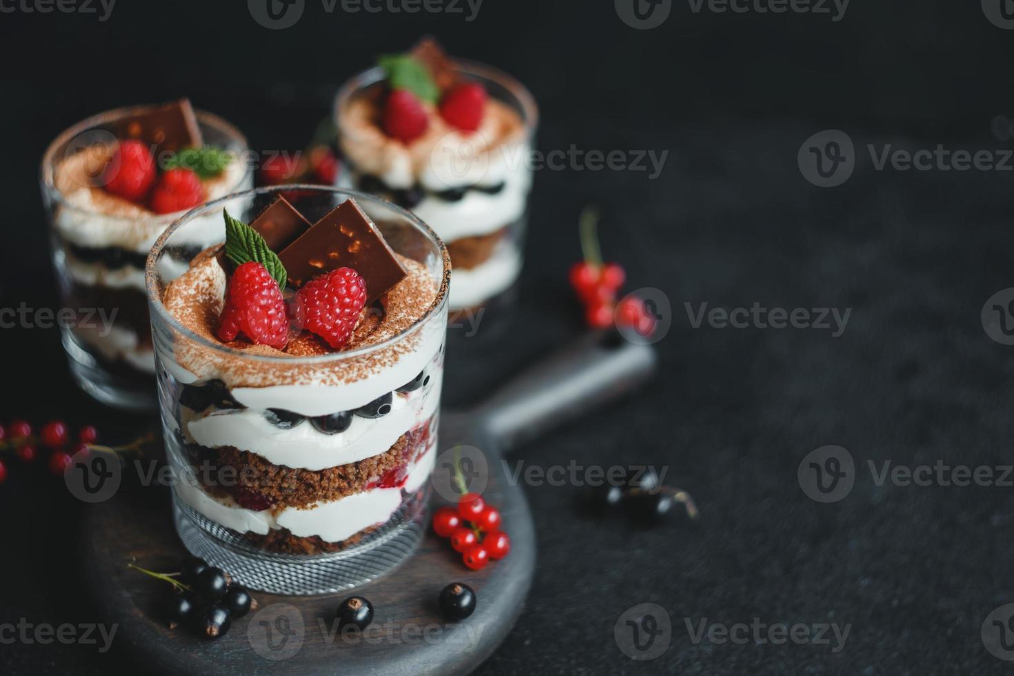 Sweet small homemade trifle dessert with raspberries, black currants, and cream cheese. photo