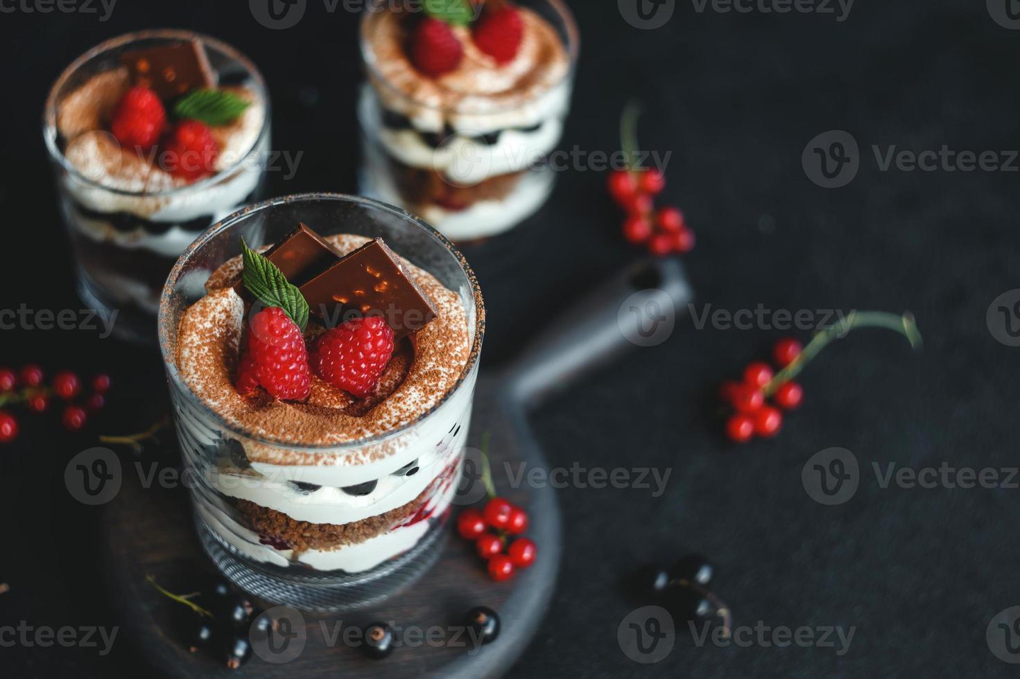 Sweet small homemade trifle dessert with raspberries, black currants, and cream cheese. photo