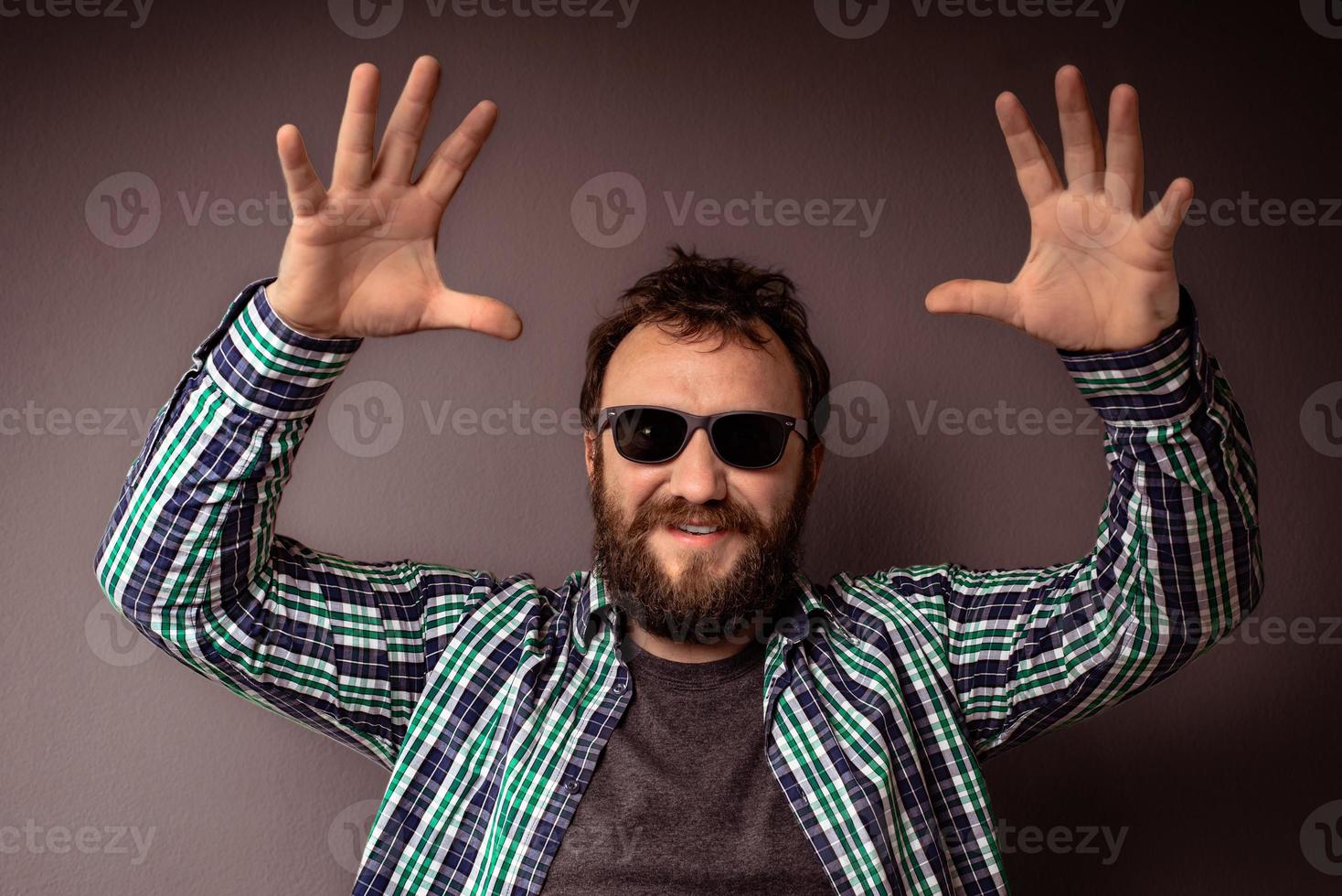 guapo, hipster, hombre barbudo, con, gafas de sol, y, camisa, con, manos arriba foto