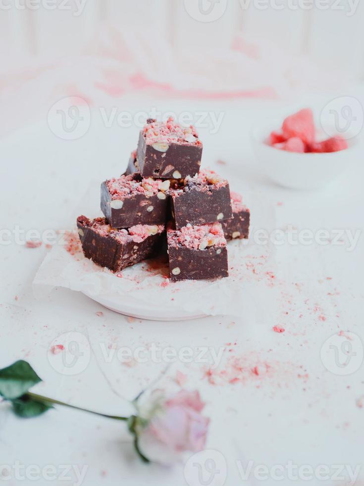 Homemade chocolate fudge with strawberries and pine nuts photo