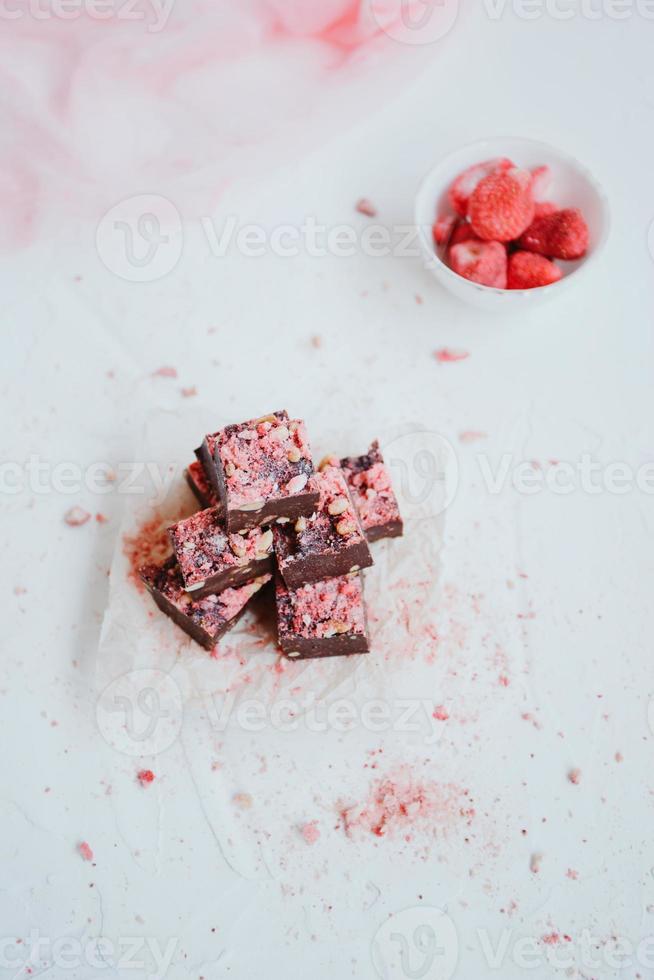 Homemade chocolate fudge with strawberries and pine nuts photo