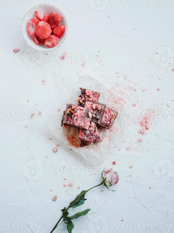 Homemade chocolate fudge with strawberries and pine nuts photo