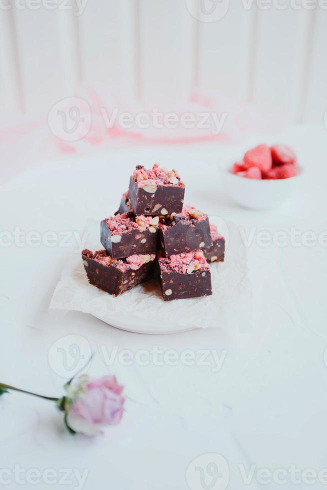 Homemade chocolate fudge with strawberries and pine nuts photo