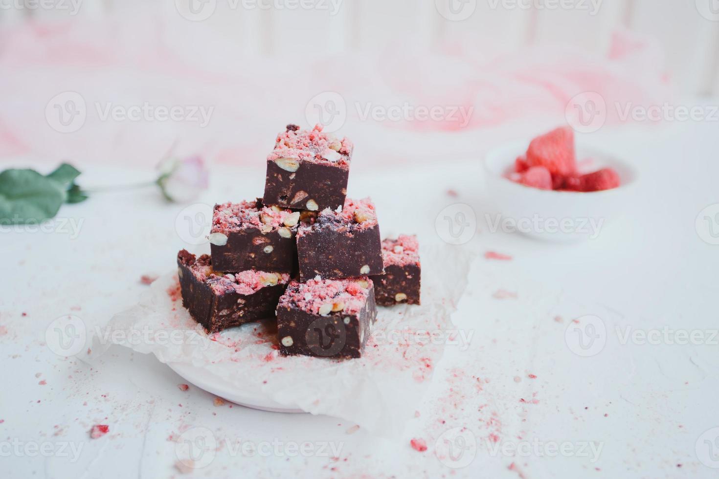 Homemade chocolate fudge with strawberries and pine nuts photo