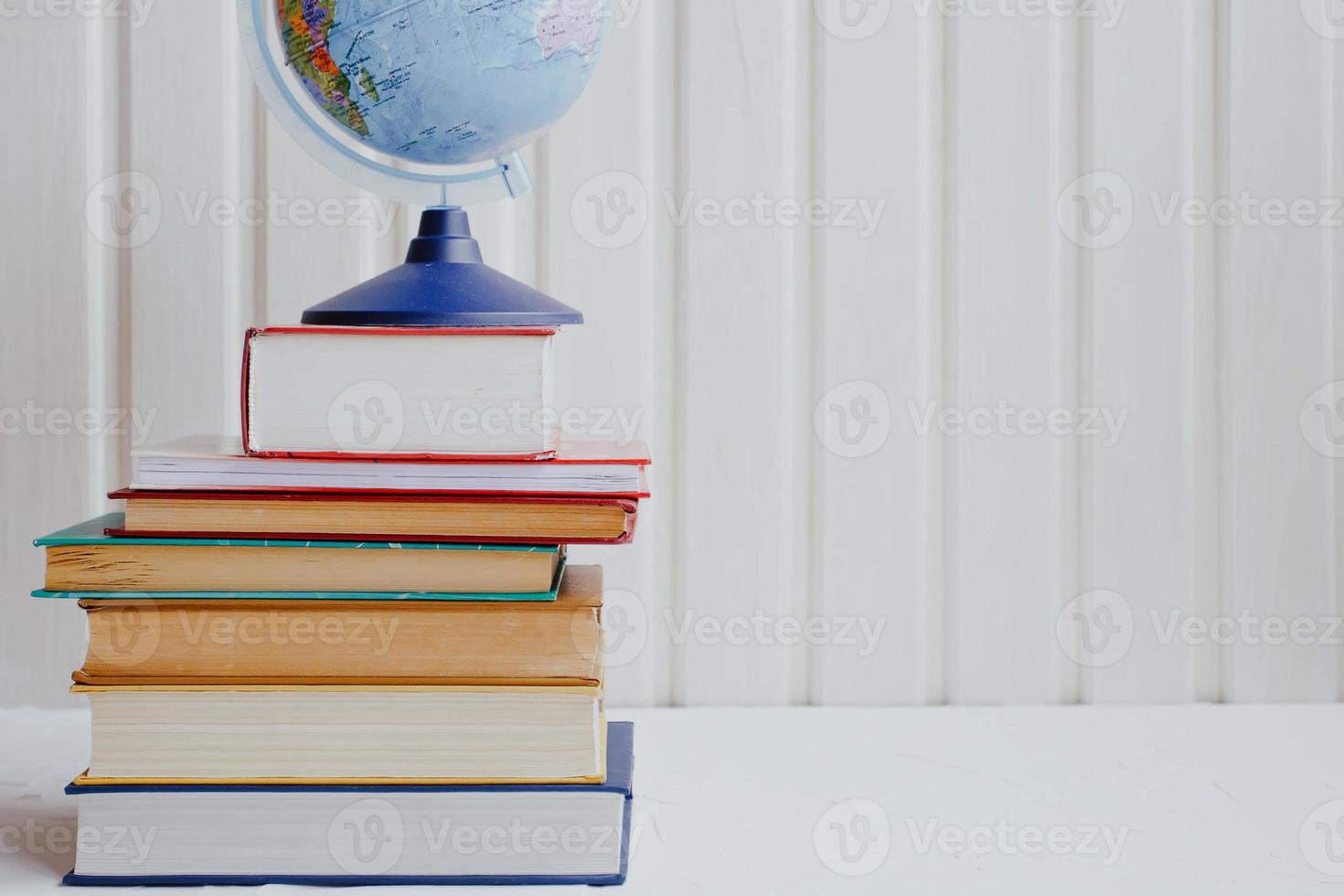 Stacks of educational books and the globe on a white background. Education concept. photo