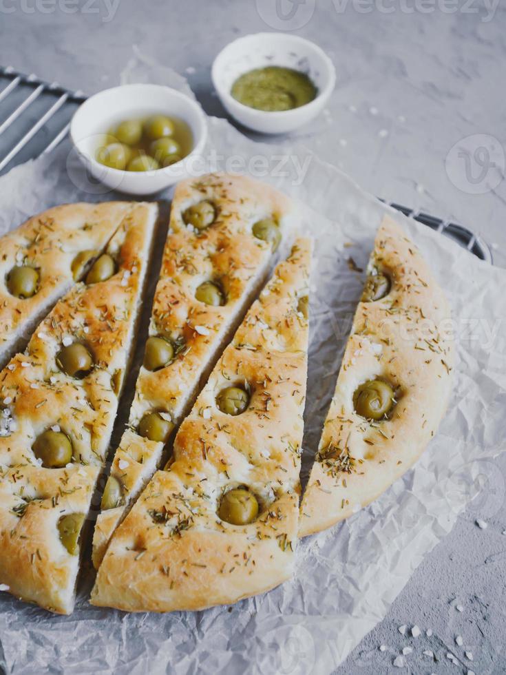 pan focaccia tradicional italiano con aceitunas, romero, sal y aceite de oliva. focaccia casera. foto