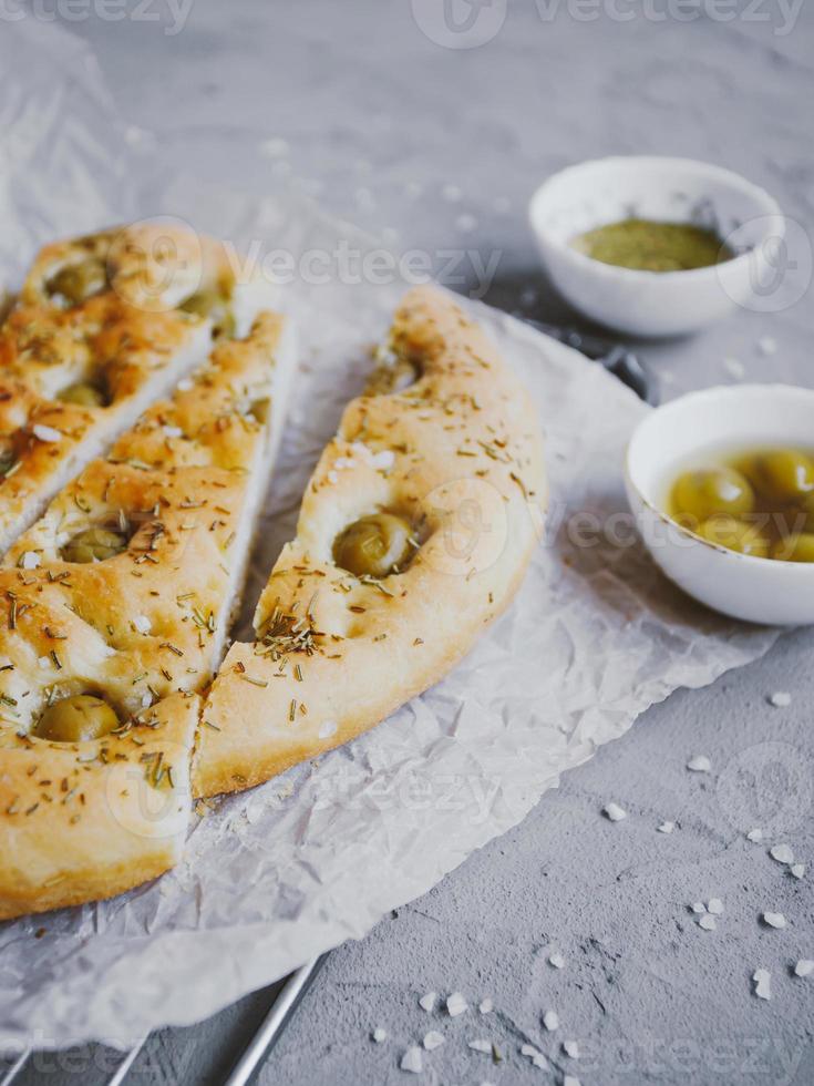 Traditional Italian focaccia bread with olives, rosemary, salt and olive oil. Homemade focaccia. photo