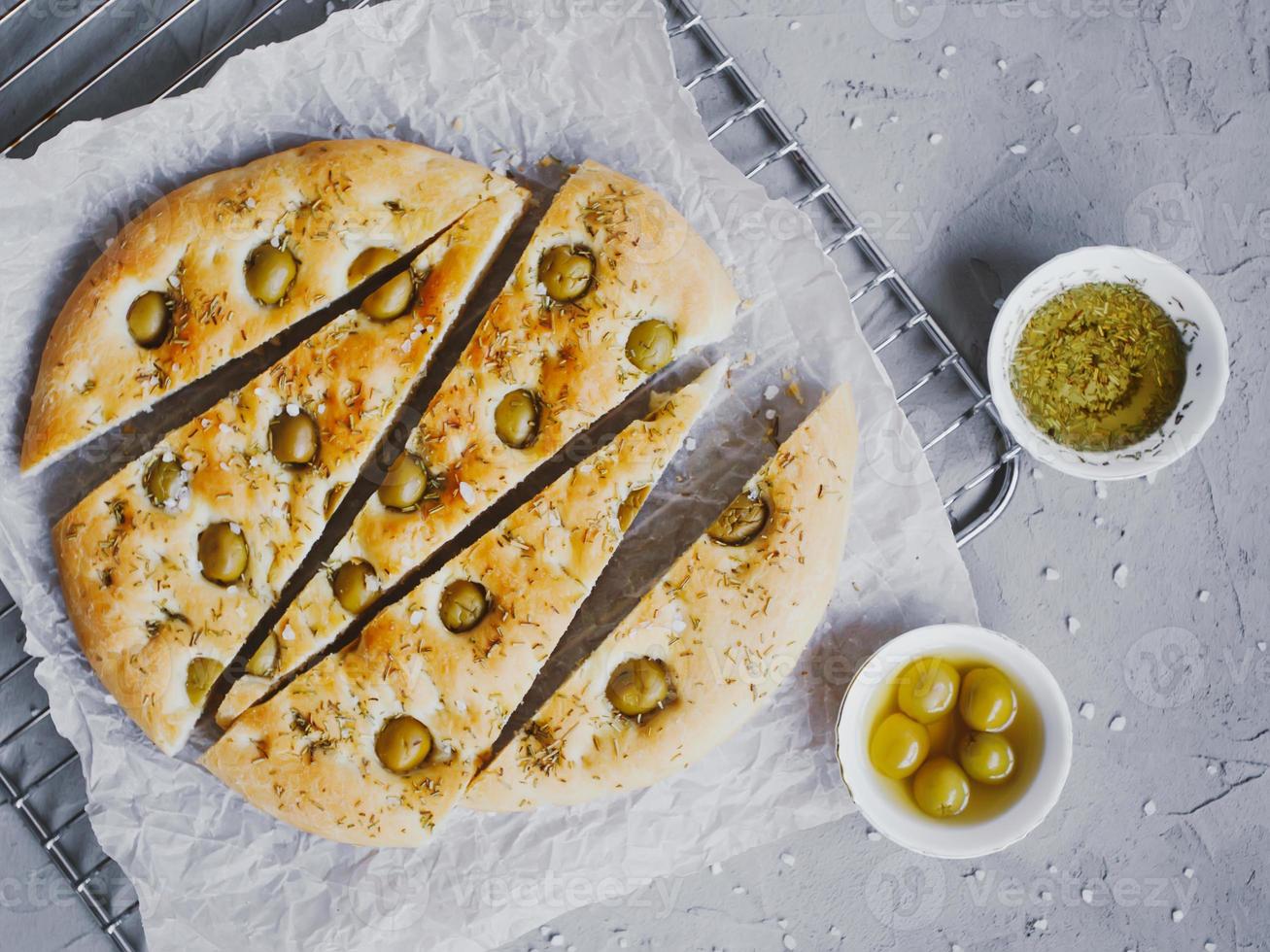 pan focaccia tradicional italiano con aceitunas, romero, sal y aceite de oliva. focaccia casera. foto