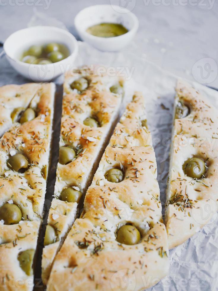 Traditional Italian focaccia bread with olives, rosemary, salt and olive oil. Homemade focaccia. photo