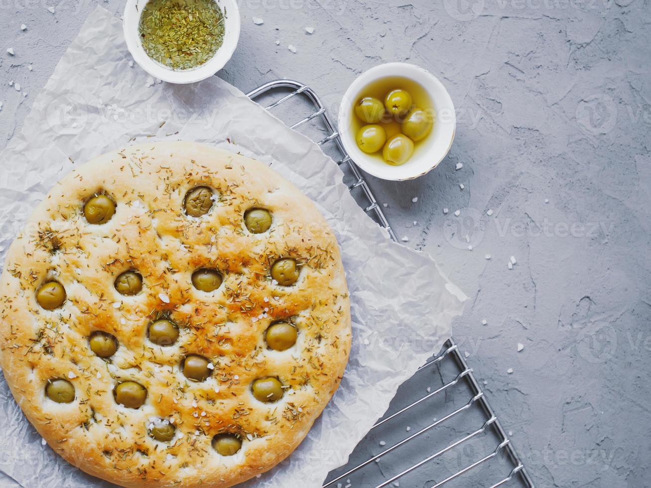 pan focaccia tradicional italiano con aceitunas, romero, sal y aceite de oliva. focaccia casera. foto