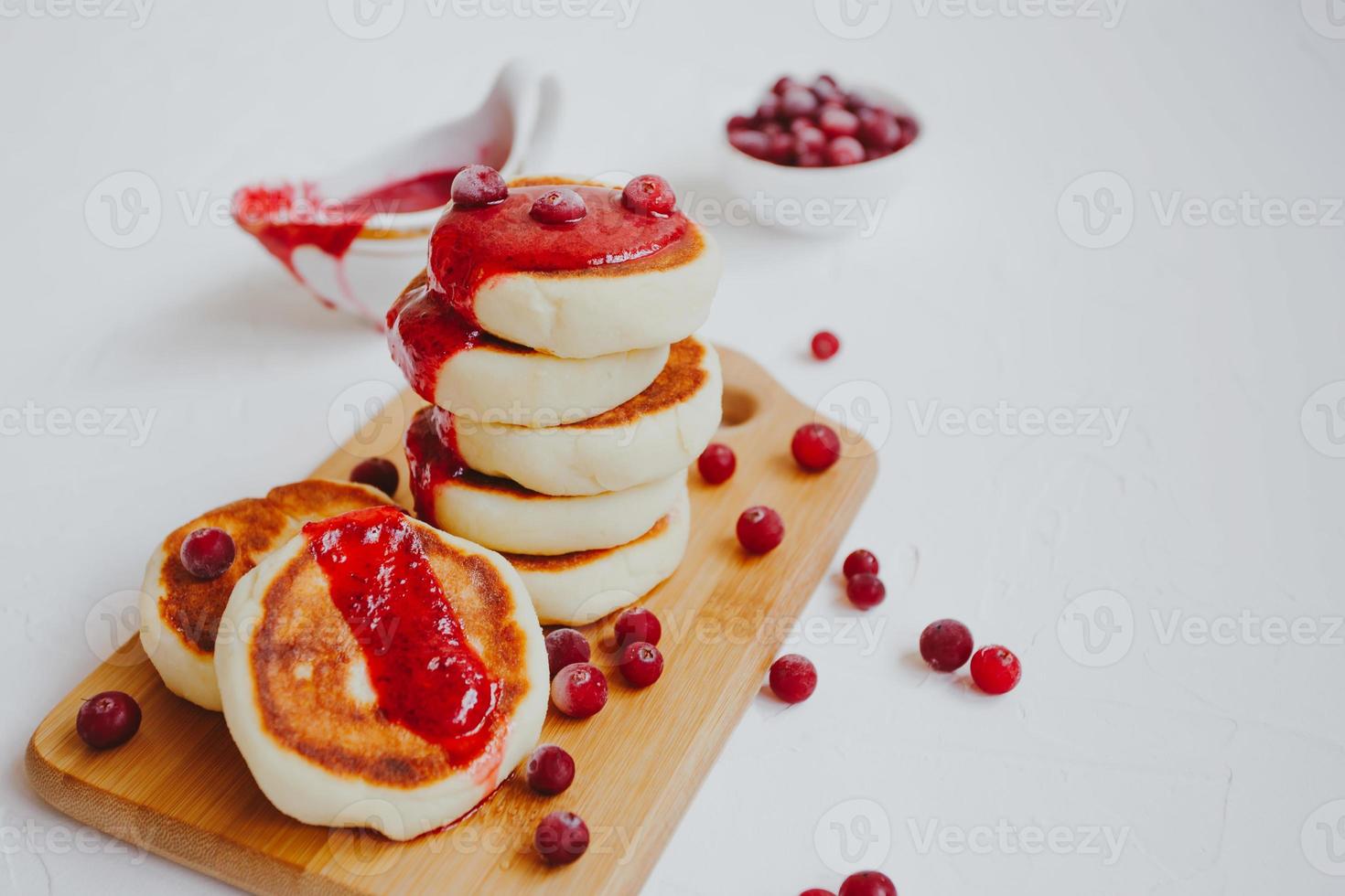 Homemade Cottage cheese pancakes or Syrniki with cranberry jam. photo