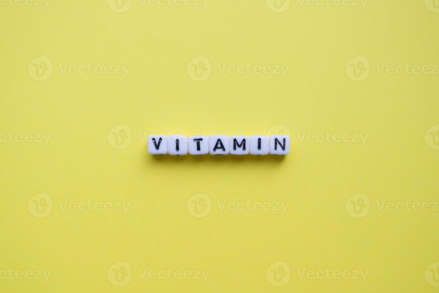 palabra vitamina sobre un fondo amarillo. foto