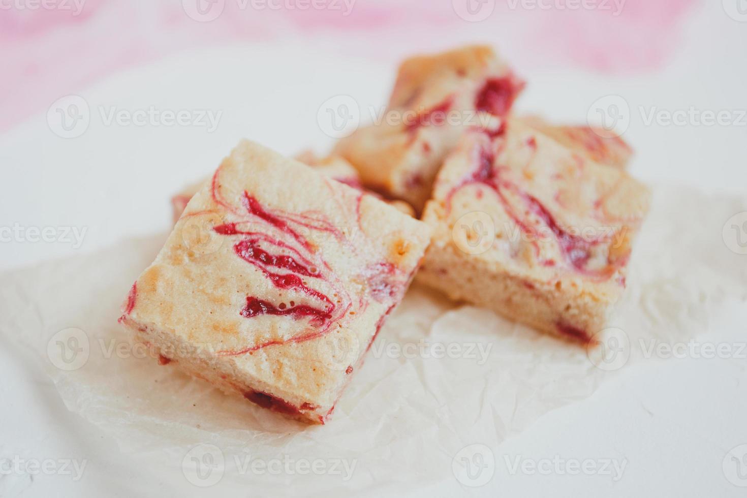 Homemade blondies, made of white chocolate with fresh raspberries, on a light background. photo