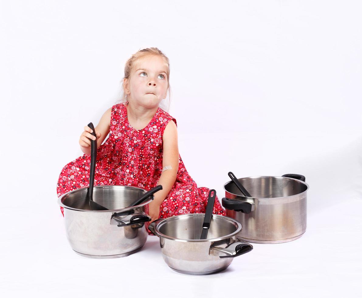 niño pequeño usando accesorios de cocina divirtiéndose foto