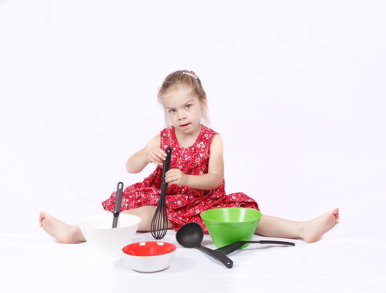 niño pequeño usando accesorios de cocina divirtiéndose foto