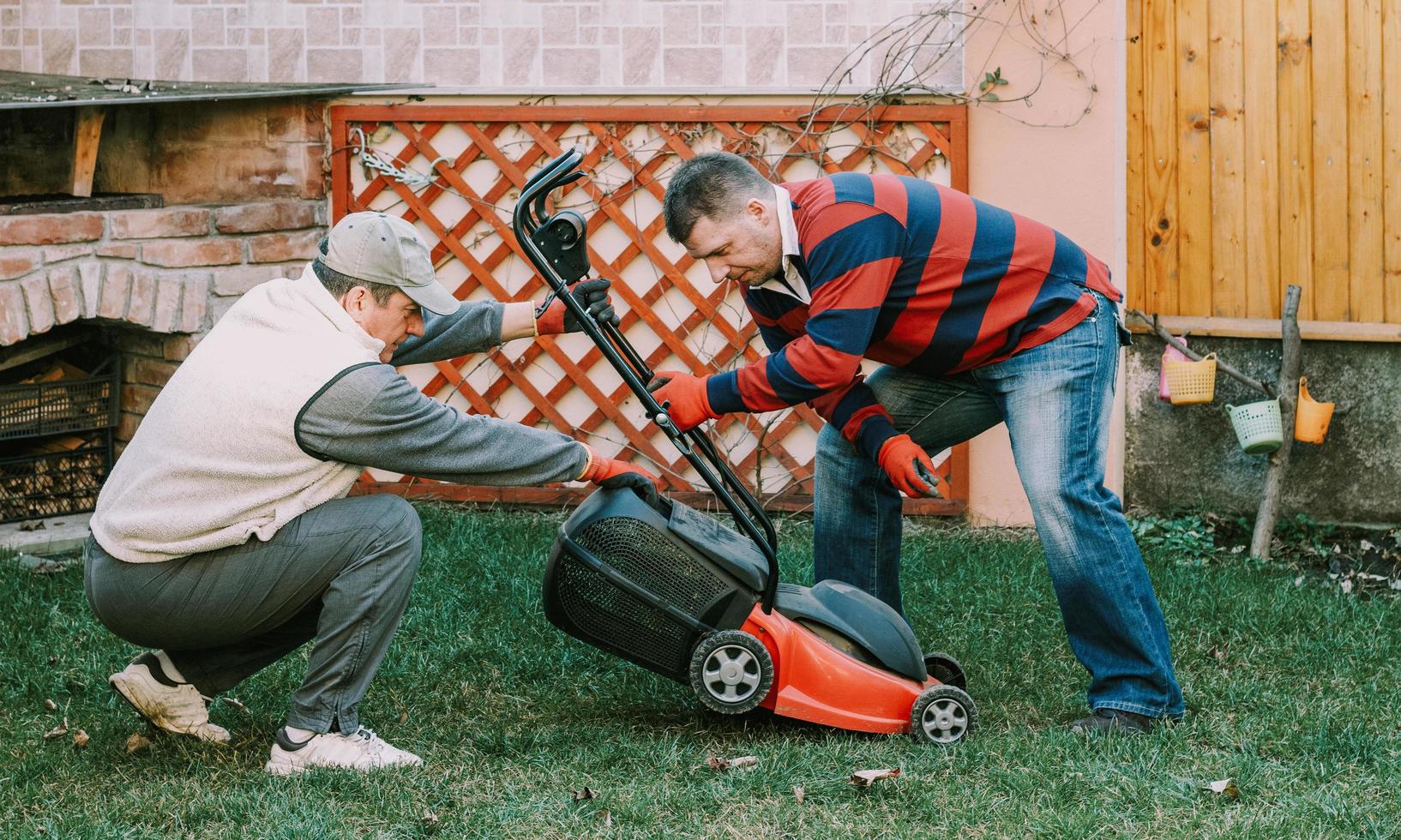 Joven adulto maduro ayudando a hombres mayores con trabajos de jardinería foto