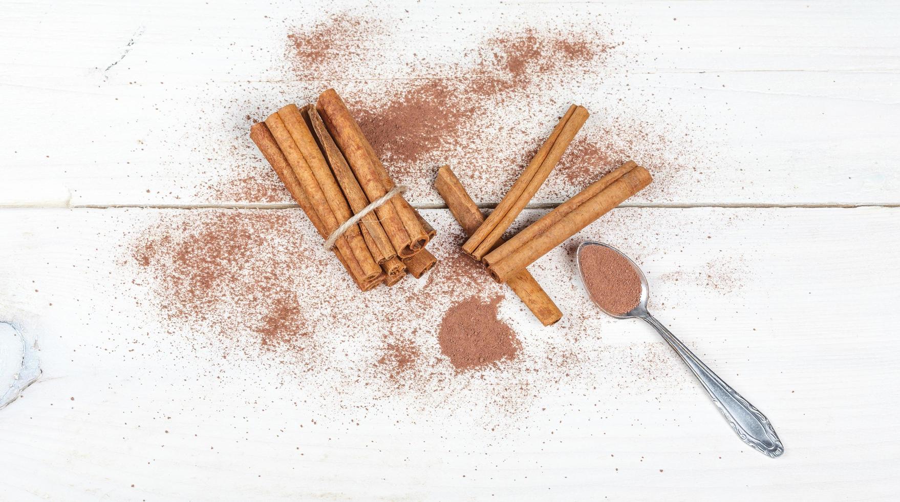 Cinnamon sticks and cocoa powder accessories for a cozy winter evening near the fireplace with a glass of wine photo