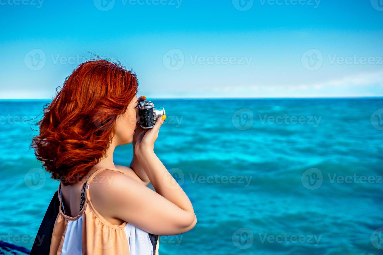 Person at ocean with camera. photo