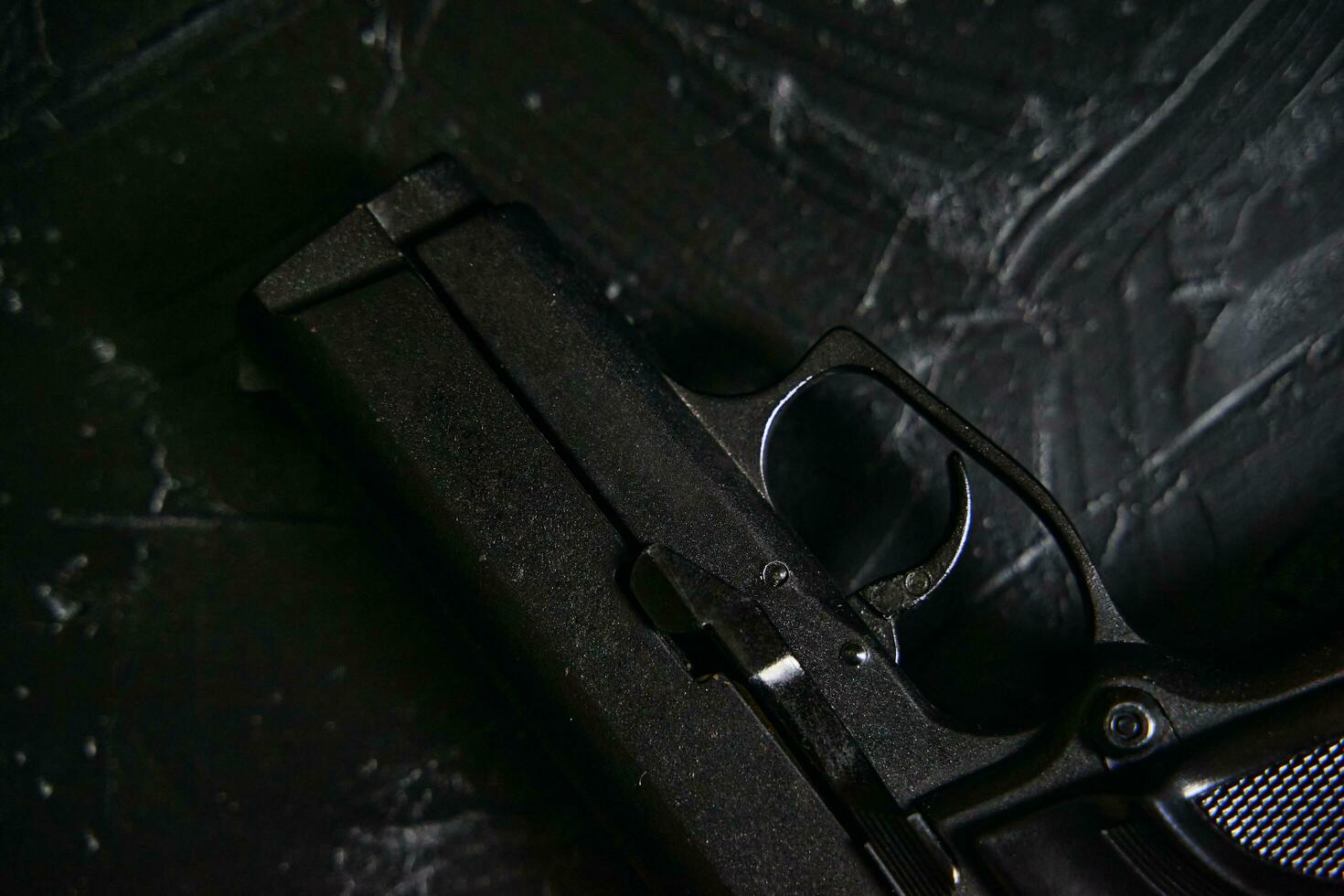 Gun on black texture table. photo