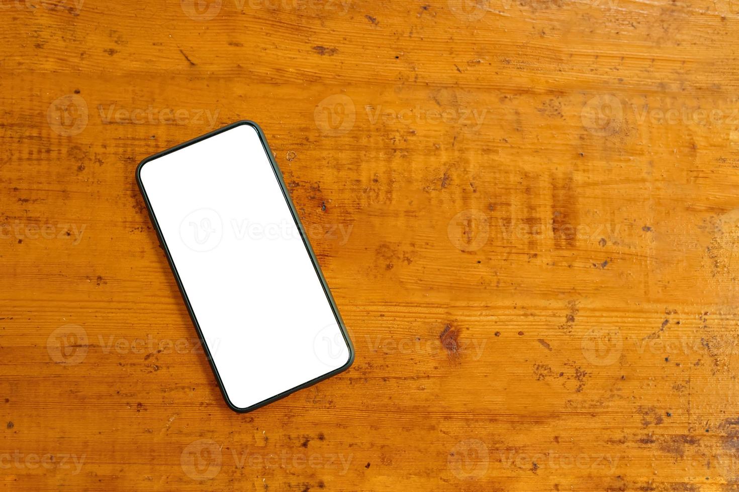 Flat lay of mobile phone on wooden table. photo