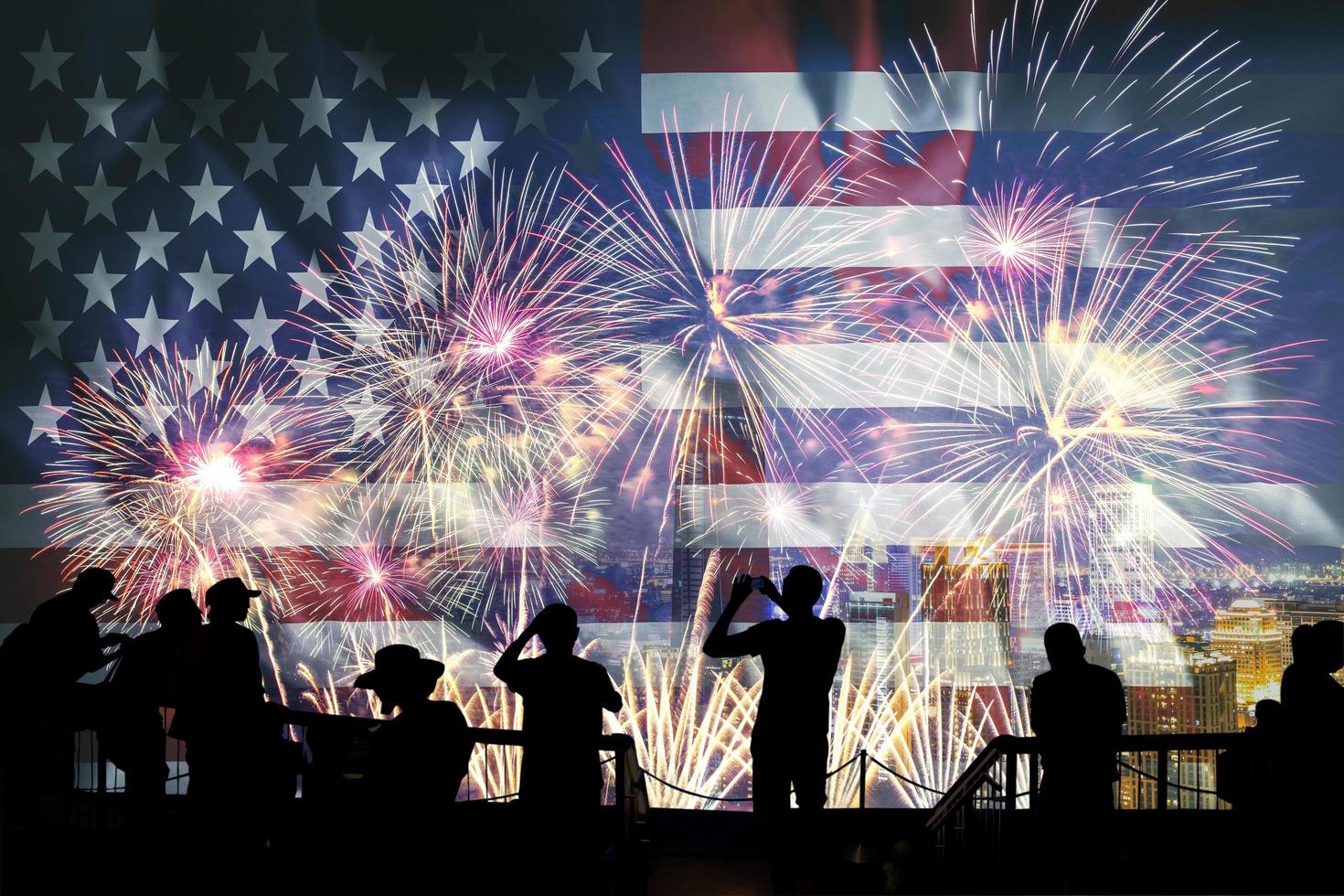 Silhouettes of people looking at fireworks and United States of America flag photo