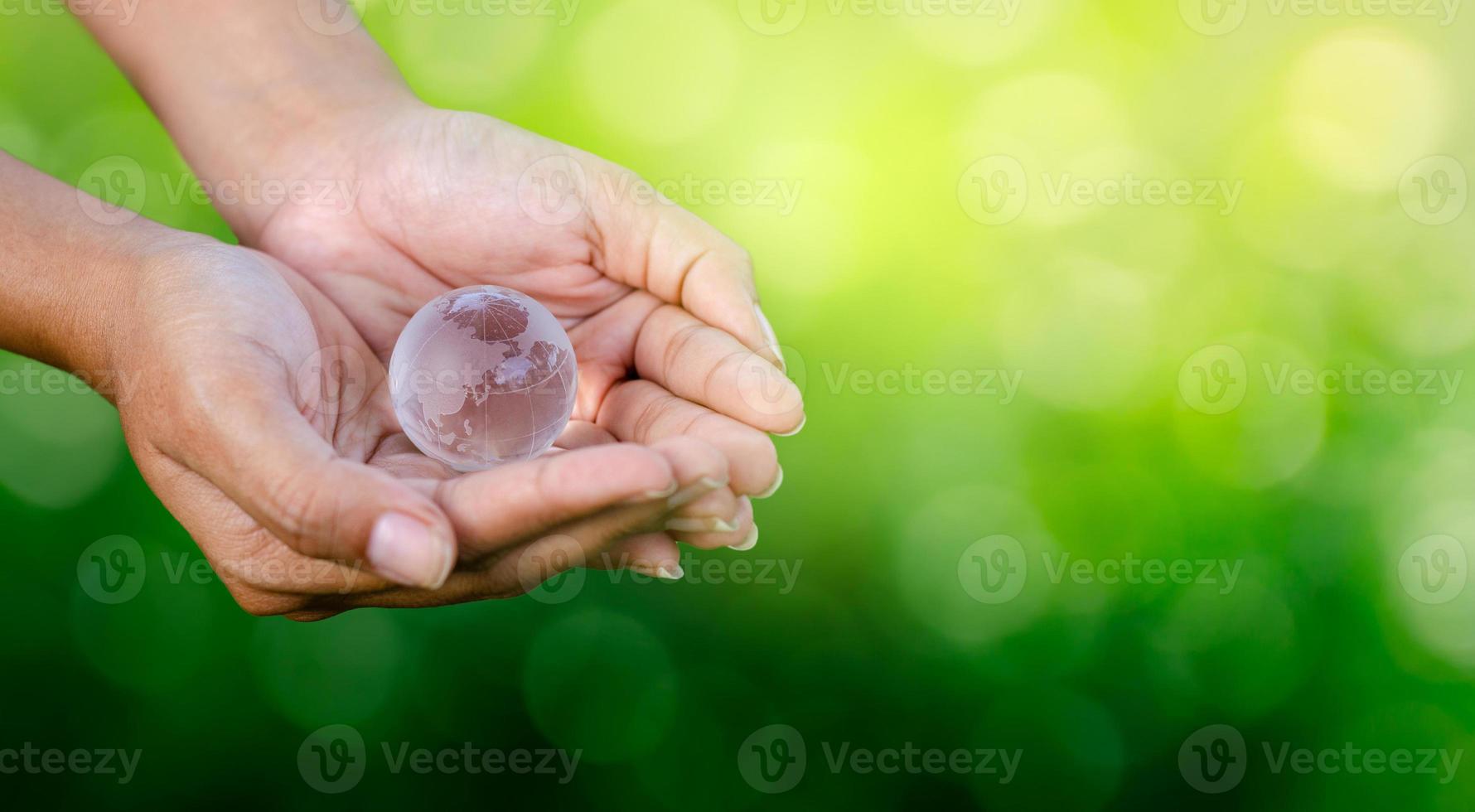 Concept Save the world save environment The world is in the hands of the green bokeh background photo