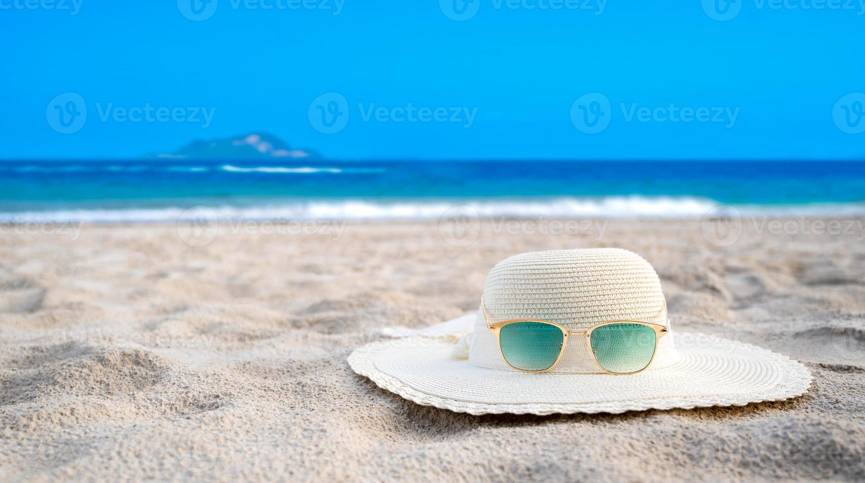 Hats and glasses are located on the sea blue sea beaches on a clear day photo