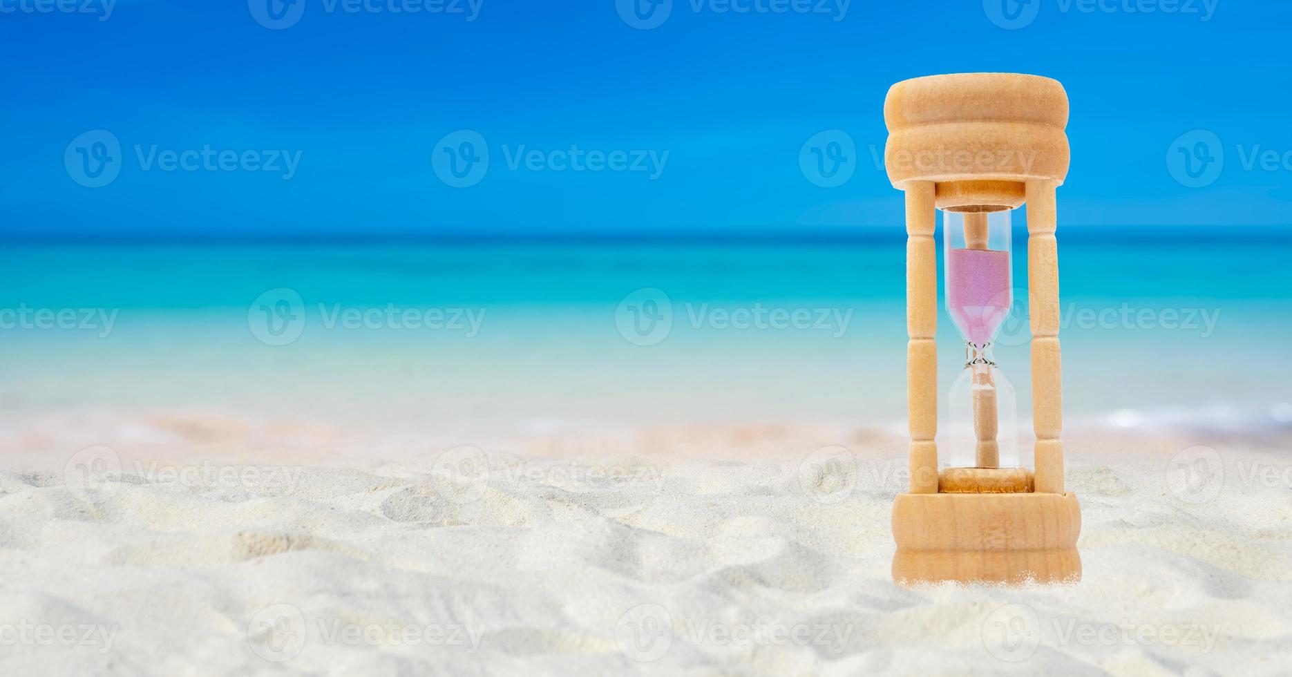 Hourglass set on a white sand background sea background, time concept photo