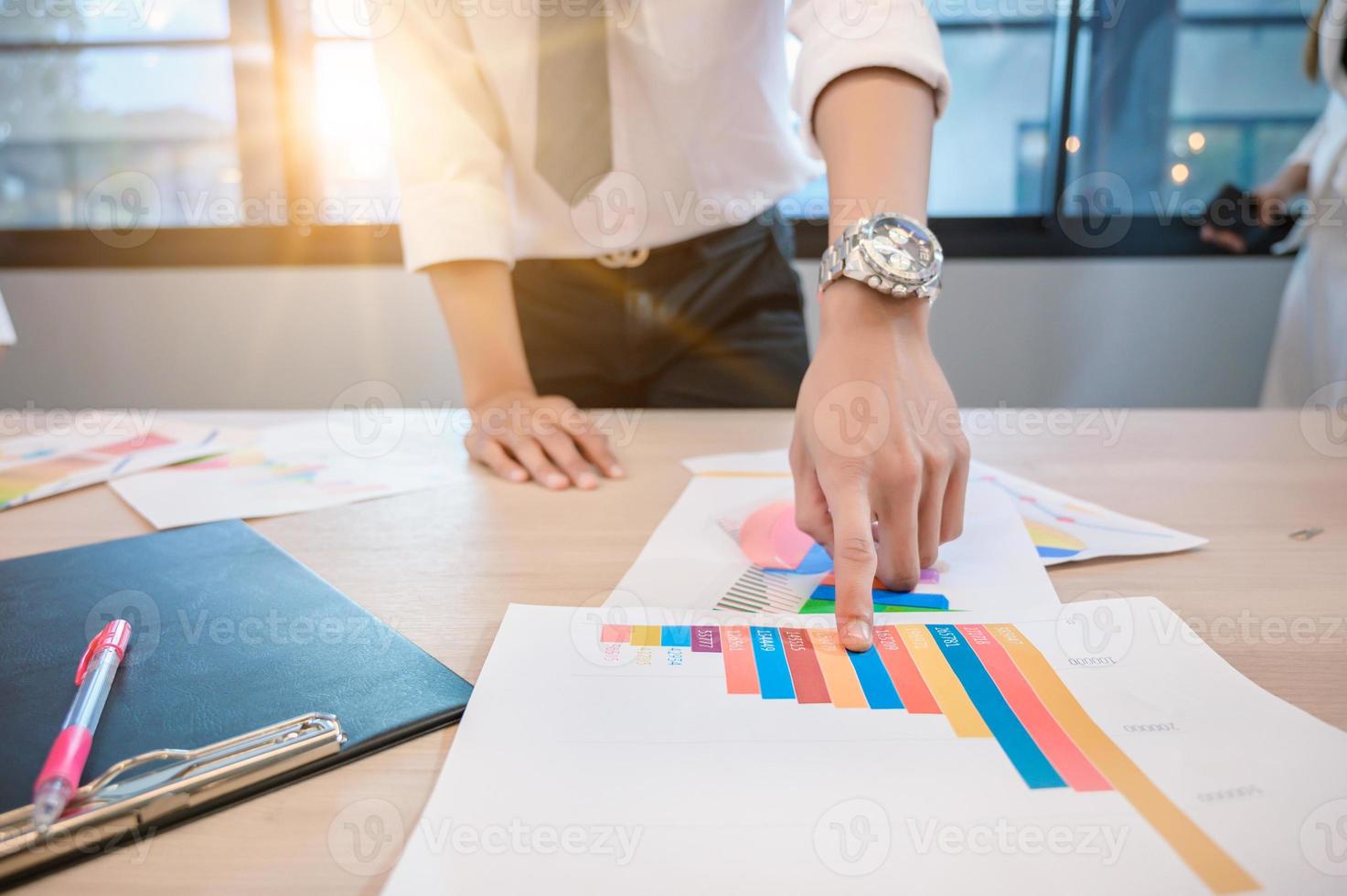 la gente de negocios se está reuniendo y graficando el crecimiento empresarial en un escritorio foto