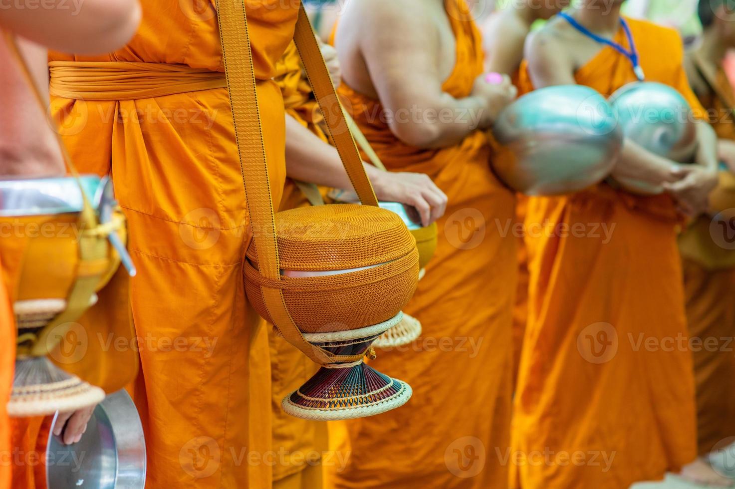 las limosnas en torno a las túnicas amarillas de los monjes caminan sobre las limosnas como una actividad budista. foto