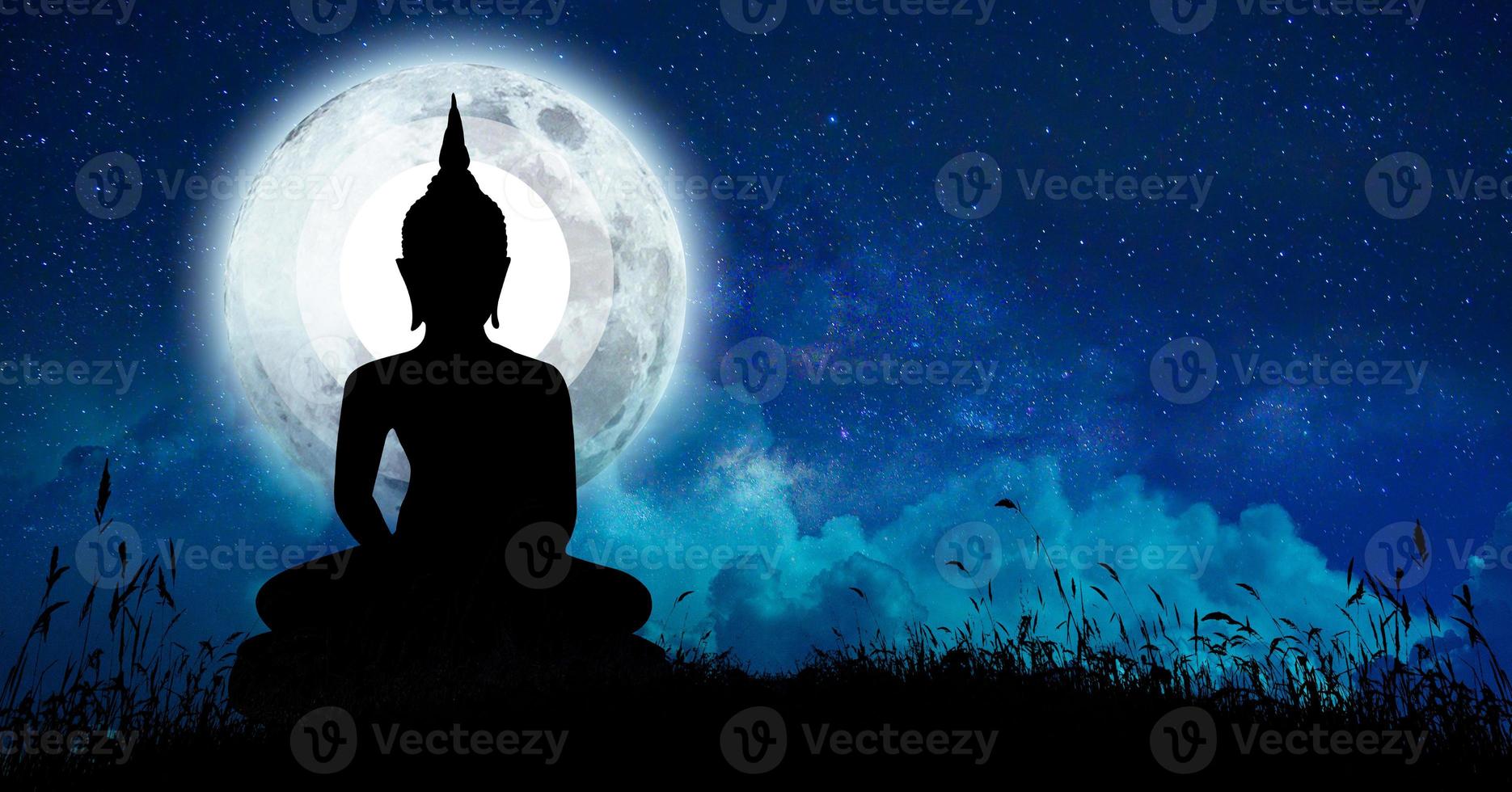 The Buddha meditated among many stars and a large moon. photo