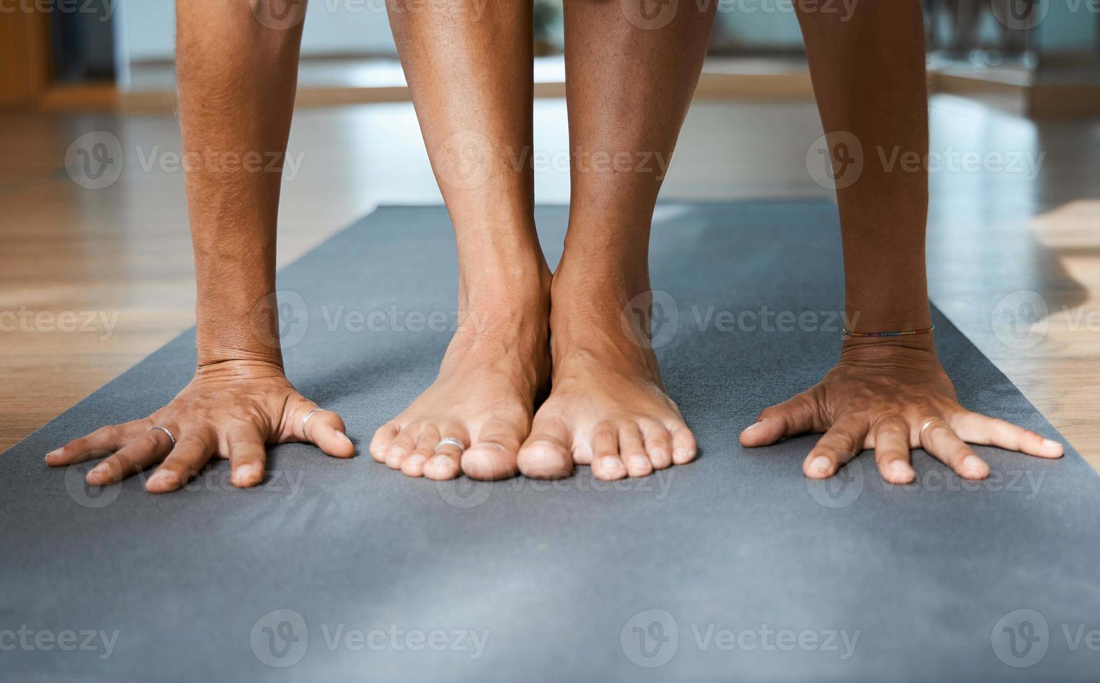 postura de flexión hacia adelante de pie en yoga iyengar, postura de pliegue uttanasana vista frontal de cerca foto