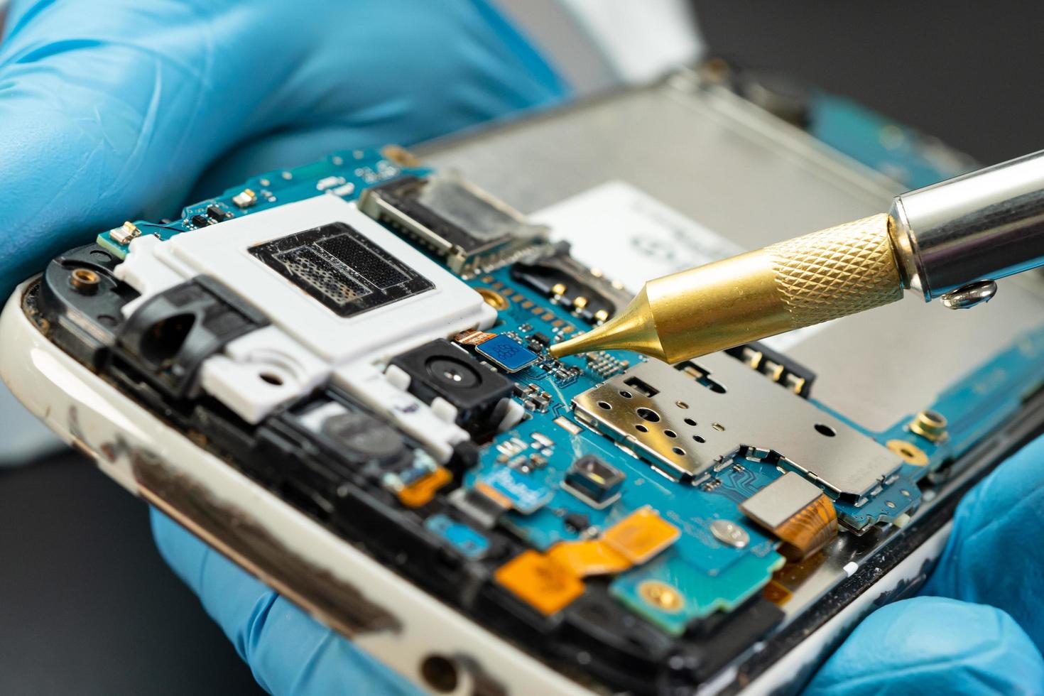 technician repairing inside of hard disk by soldering iron. Integrated Circuit. the concept of data, hardware, technician and technology. photo