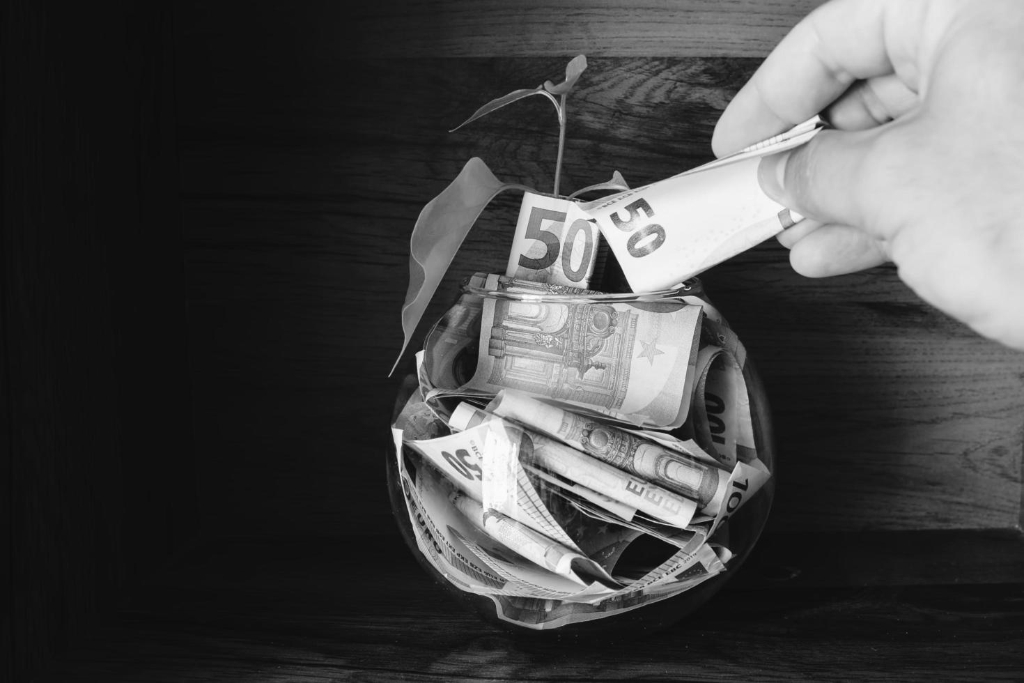 Hand holds fifty euro paper note adds to savings bowl. Investment holdings in hugh currency. photo