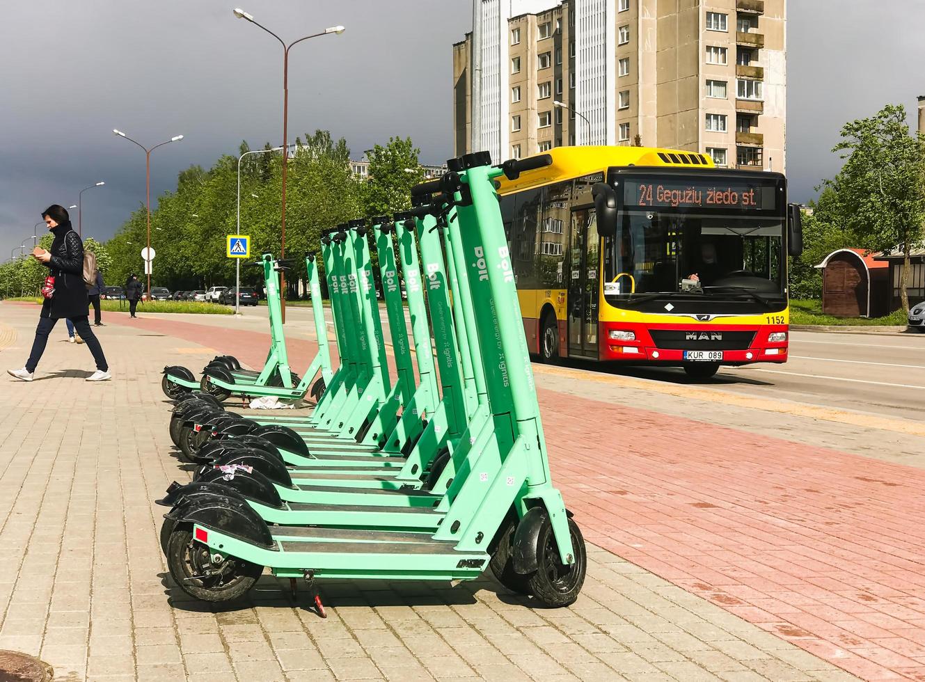 siauliai, lituania, 27 de mayo de 2021 - scooters eléctricos y autobuses en la ciudad foto