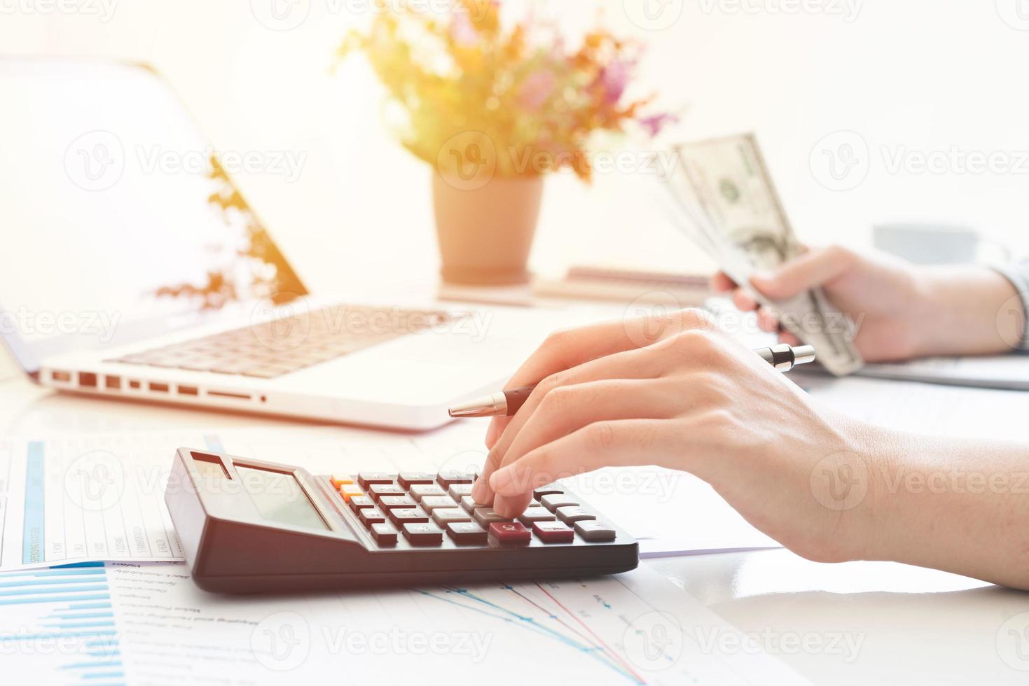 Businesswoman using a calculator and writing notes. Taxes, savings, finances, and economy concept photo