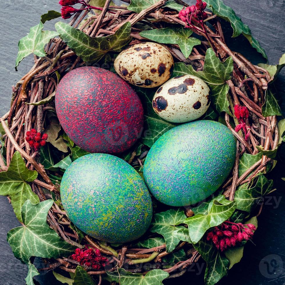 huevos de pascua con decoración huevos de codorniz y gallina en un nido de pájaros. foto