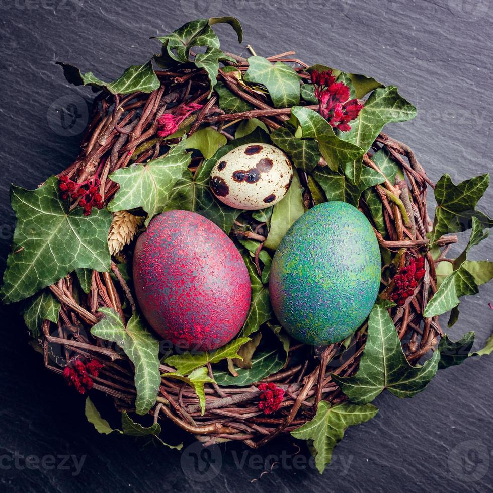 huevos de pascua con decoración huevos de codorniz y gallina en un nido de pájaros. foto