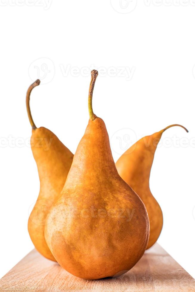 Three Williams or Bartlett pears on wooden table with isolated white background. photo