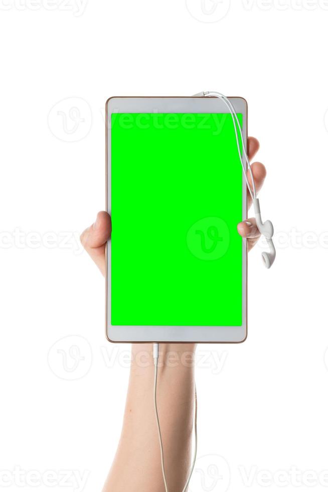 Male hand holds white tablet with plugged in headphones. Isolated screen with chroma key and all isolated on white background. photo