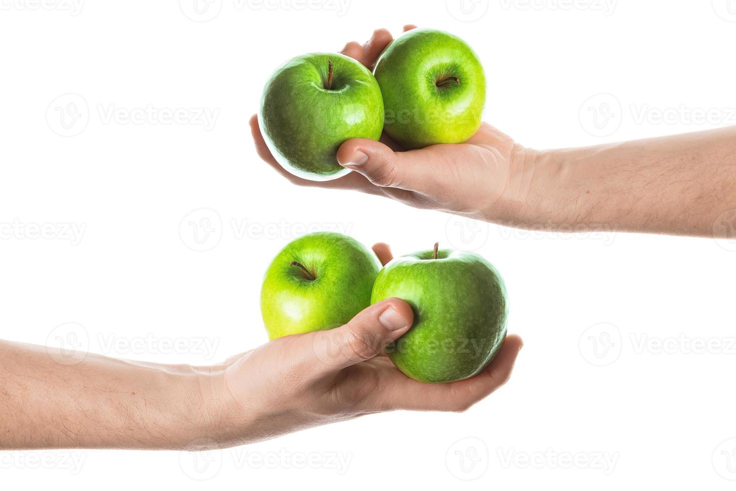 hombre sosteniendo dos manzanas verdes en la mano. aislado sobre fondo blanco. foto