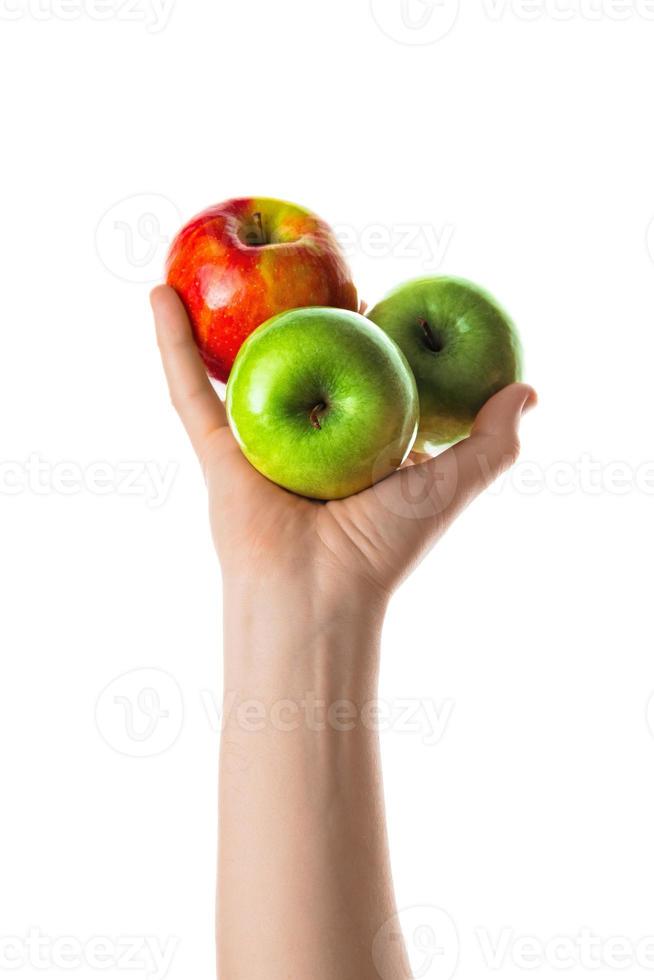 hombre que sostiene un montón de manzanas rojas y verdes en la mano. aislado sobre fondo blanco. foto