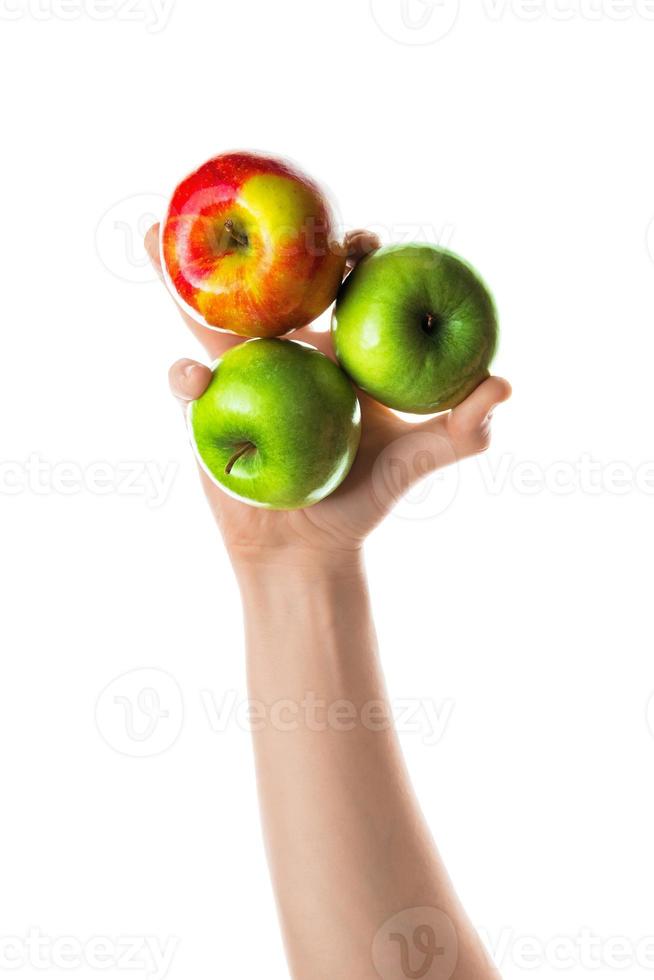 hombre que sostiene un montón de manzanas rojas y verdes en la mano. aislado sobre fondo blanco. foto