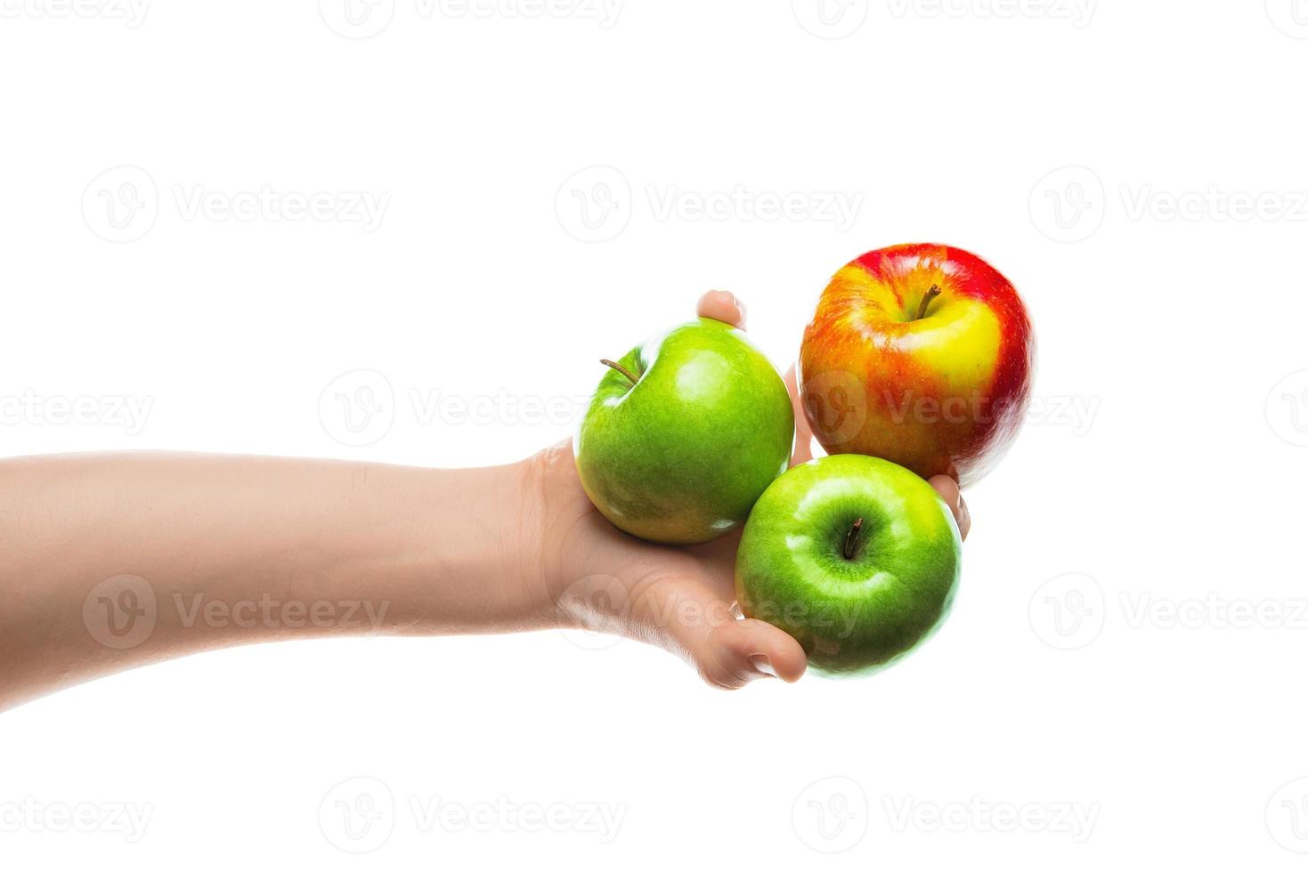 Man holding bunch of red and green apples in his hand. Isolated on white background. photo