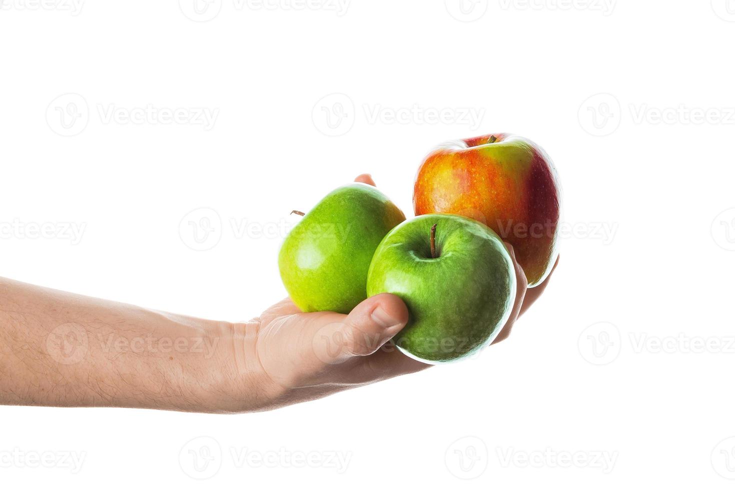 hombre que sostiene un montón de manzanas rojas y verdes en la mano. aislado sobre fondo blanco. foto