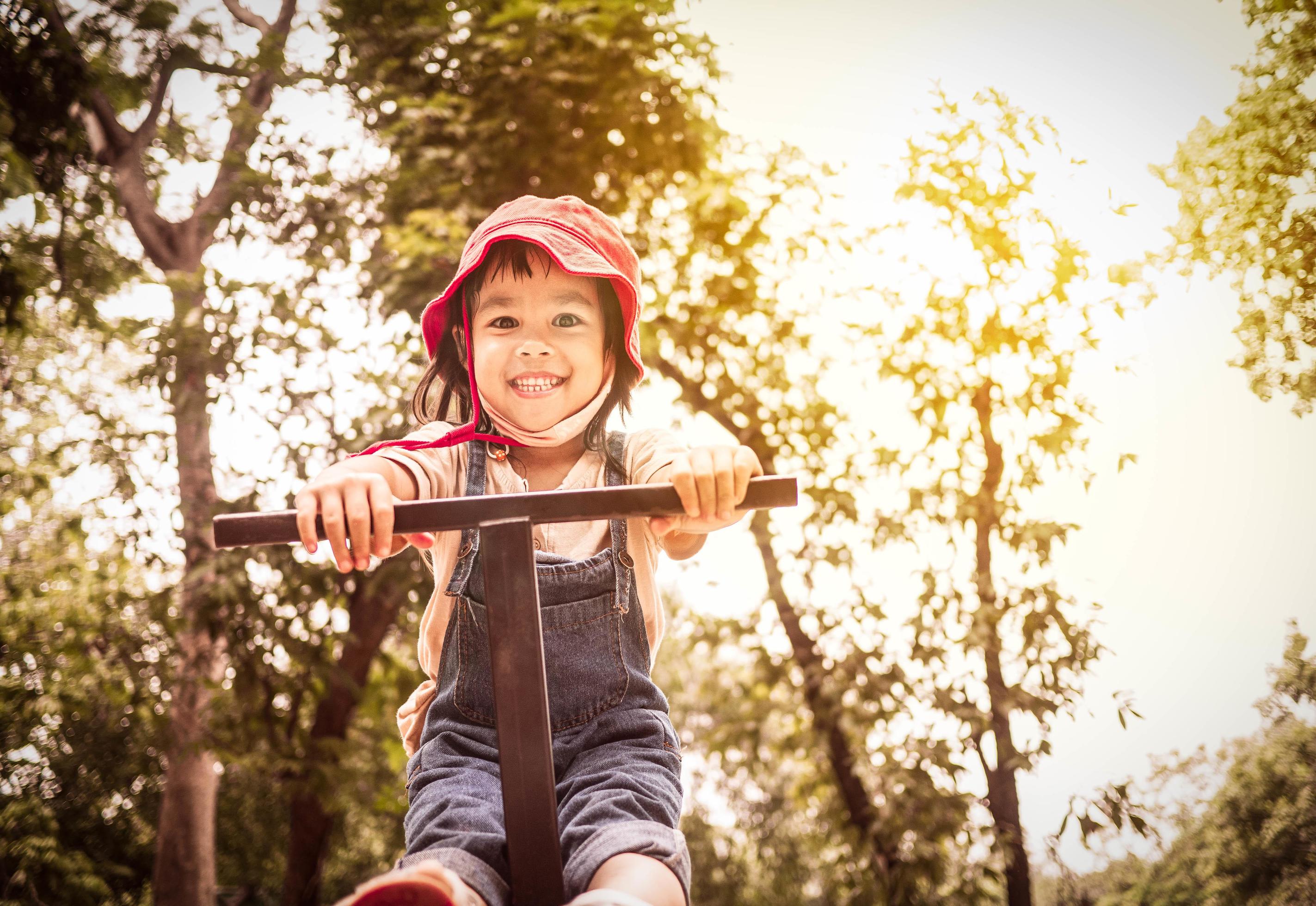 Happy child girl playing in the playground outdoor in summer time