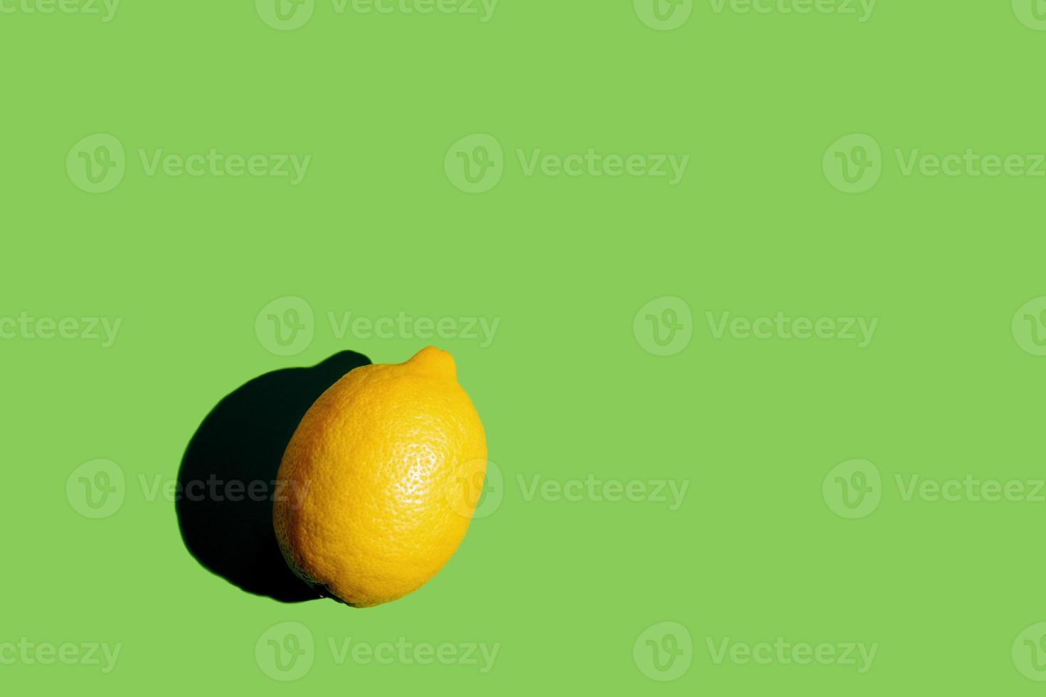 A lemon with hard shadow in pop art style isolated on green background photo